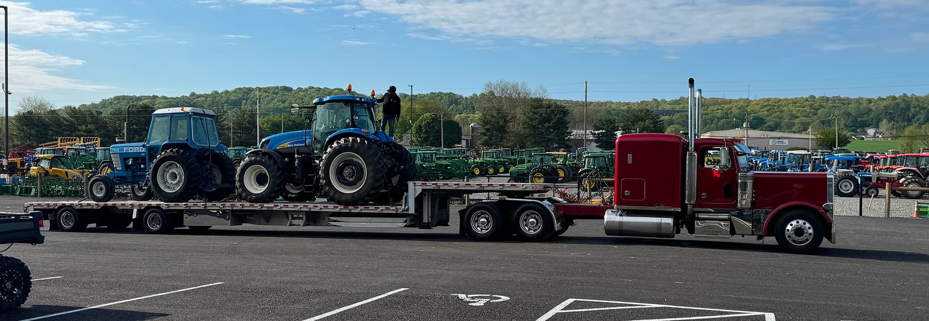 two blue tractors on a truck