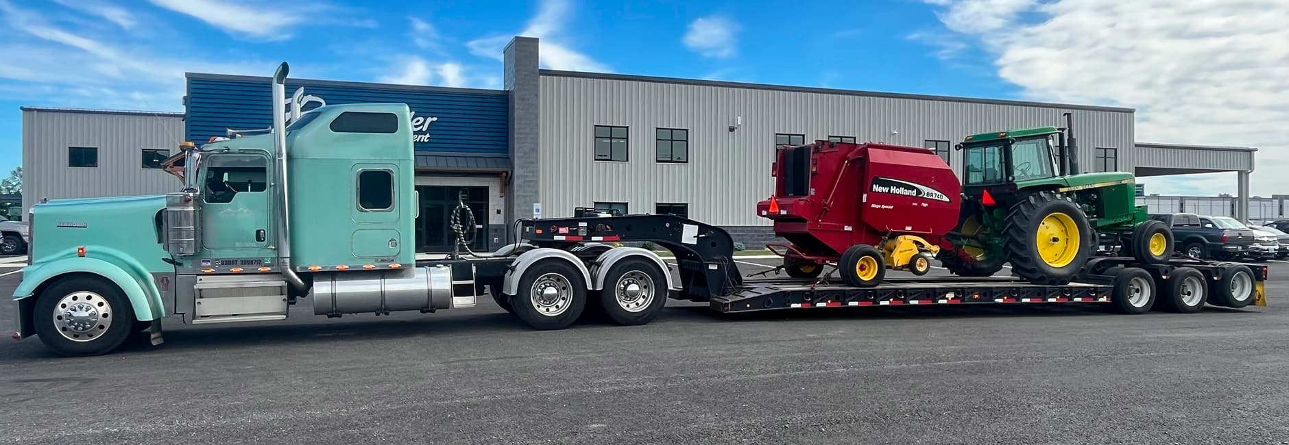 blue truck towing farm equipment